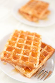 Waffles spread with honey in a plateful on a tale 