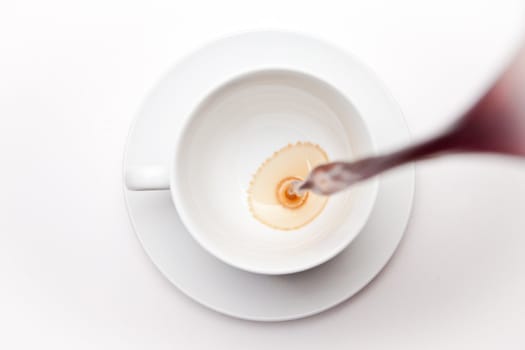 Empty coffee cup being filled against a white background 