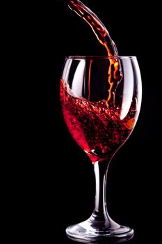 Wine glass being filled  against black background