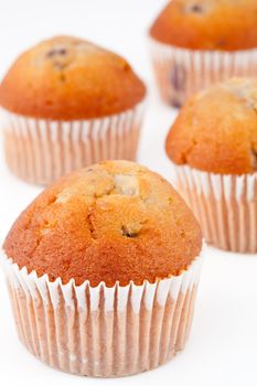 Four small baked muffins against a white background