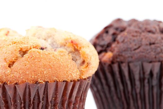 Close up of a regular muffin and a chocolate muffin against a white background