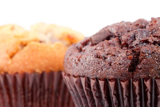 Close up of  chocolate muffin and a regular muffin against a white background