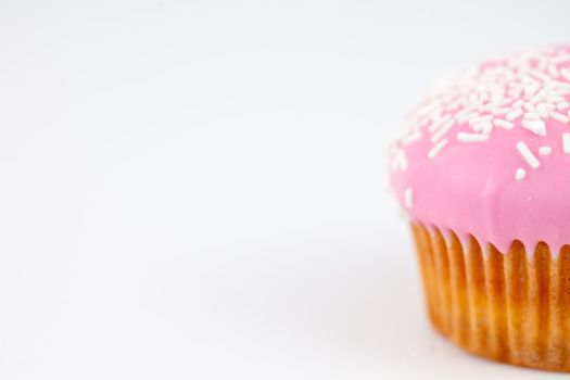 Close up on a muffin with icing sugar against a white background