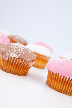 Muffins with icing sugar lined up against a blue background