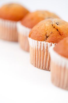 Close up on four muffins against a white background