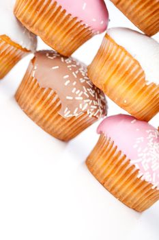 Close up on many muffins with icing sugar against a white background