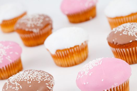 Blurred muffins with icing sugar against a white background
