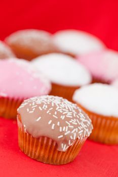 Muffins with icing sugar on a red tablecloth 