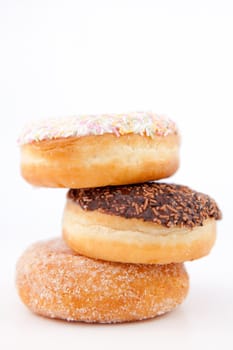 Pile of three doughnuts against a white background