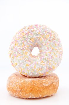 Doughnut with multi coloured icing sugar against a white back ground