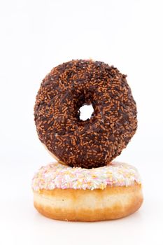 Doughnuts with multi coloured icing sugar against a white background