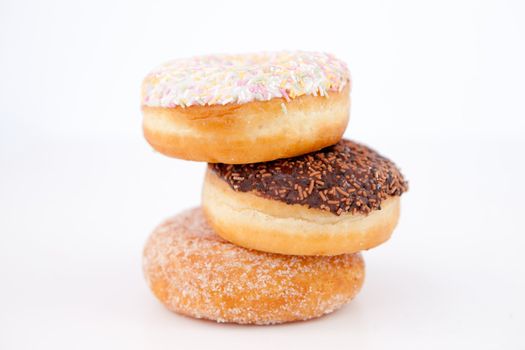 Doughnuts piled up against a white background