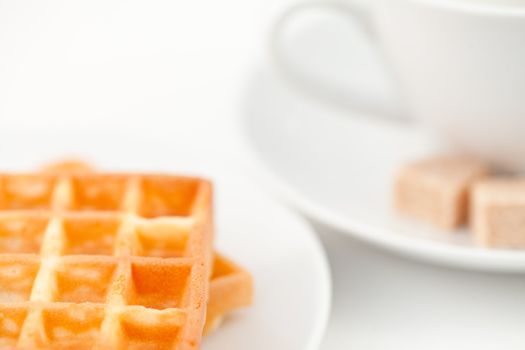 waffles sugar and coffee on white plate against a white background