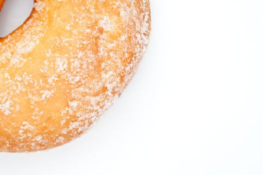 Close up of doughnut with icing sugar against a white background