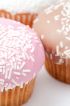 extreme close up of many muffins with icing sugar against a white background