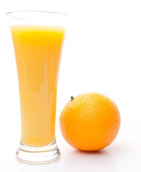 Orange next to a glass of orange juice against white background