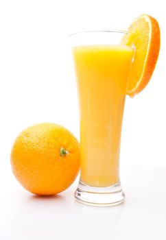 Orange near a glass of orange juice against white background