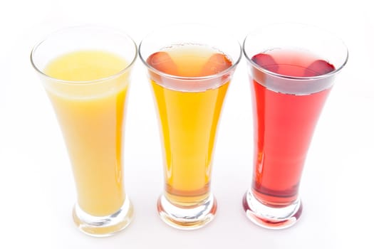 Three glasses full of fruit juice against white background