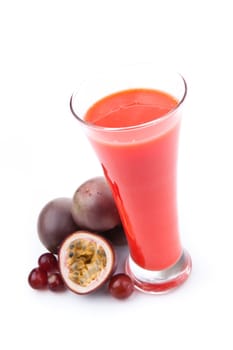 Full glass near passion fruits against white background