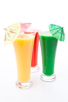 Cocktail umbrella in three glasses against white background