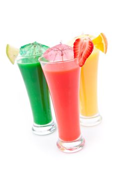 Fruit pieces and cocktail umbrella on glasses against white background