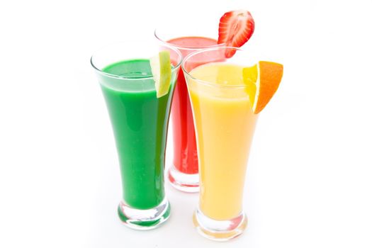 Fruit pieces in three full glasses against white background