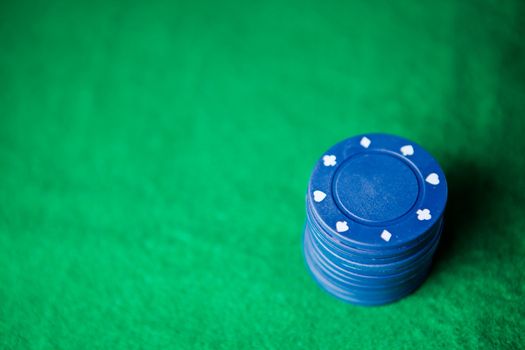 Blue poker chips on the green mat