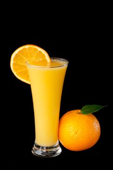 Orange juice with orange slice against a black background
