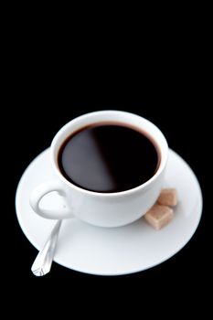 Cup of coffee  with brown sugars against a black background