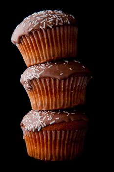 Three cakes on balance against a black background