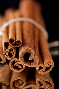 Close up of cinnamon sticks against a black background