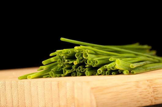 Stands of chive against a black background