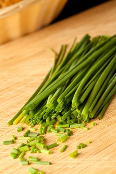 Freshly cut stands of chive on a wooden table