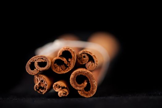 Six cinnamon sticks packed together against a black background