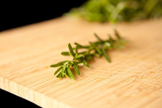 Thyme on a wooden table against a black background