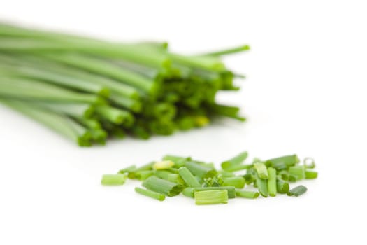 Freshly cut stands of  blurred chive against a white background
