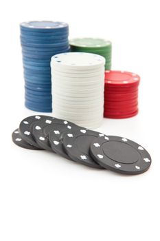 Many poker tokens piled up against a white background