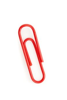 Close up of a red paperclip on the floor against a white background