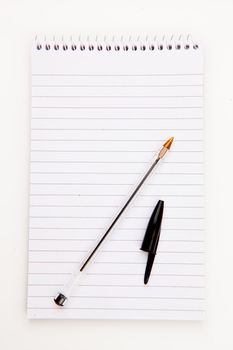 Notepad  with black pen sheet  against a white background