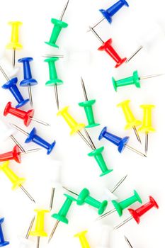 Close up of large group of multi coloured pushpins against a white background