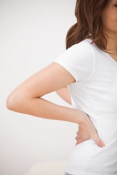 Woman massaging her painful back in a medical room