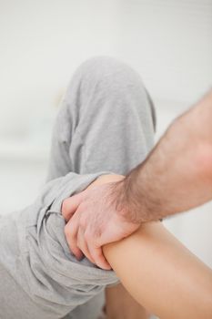 Practitioner looking at the leg of his patient in a room