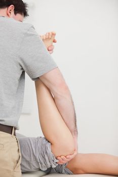 Woman lying forward while being manipulated by a doctor in a room