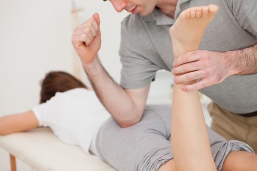 Woman lying while being massaged by her doctor in a room