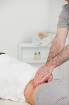 Woman lying while a physiotherapist is massaging her back in a physio room