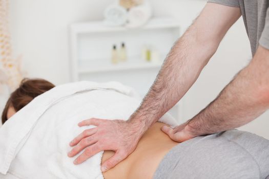 Masseur massaging the back of a woman in a room