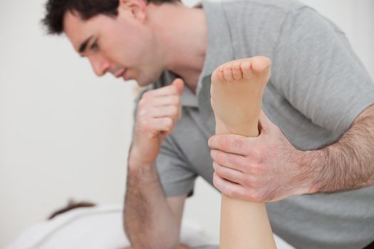 Physio manipulating the leg of a patient in a room