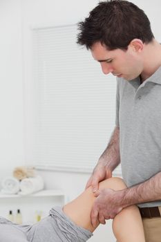 Chiropractor massaging a knee in a physio room