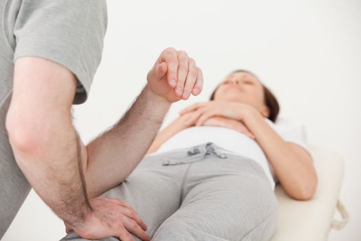 Masseur massaging the thigh of a woman in a physio room