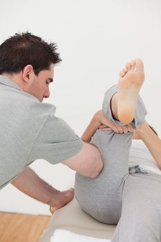 Chiropractor massaging the leg of a woman in a room